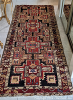 Full view of runner rug laid on tiled floor showing overall geometric design and condition
