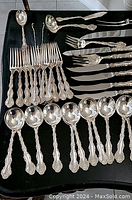 Overhead view of forks, spoons and serving utensils displayed on black surface