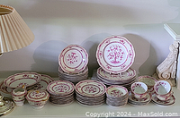 Full display of dinnerware set on shelf showing plates, bowls, cups, saucers, platter, bowl and tureen.
