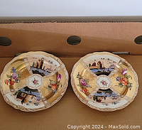 Pair of Meissen plates showing top view with scenic designs and gold accents
