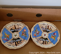 Pair of two hand-painted Meissen porcelain plates with blue and gold accents captured in the box showing both plates together.