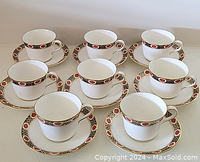 Photo of all 8 Royal Crown Derby teacups with matching saucers arranged together on a table showing pattern and quantity.
