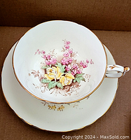Top view of teacup inside saucer displaying detailed floral pattern with gold trim.