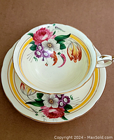 Teacup sitting inside the saucer showing flower designs and gold accents