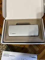 Top view of Belkin Express Dock HD in original packaging showing silver dock and Belkin logo.