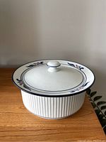 Closed casserole pot showing floral patterned wide rim lid and ribbed body