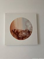 Front view of the square wooden panel painting with an abstract circular design of browns and neutrals.