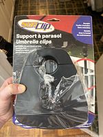 Front view of the Sun Clip umbrella clip in sealed packaging, showing product name and clip shape.