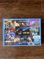 Closed puzzle box with colorful collage featuring main characters and starship from Star Trek The Original Series.