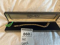Full view of the 14K gold watch bracelet strap inside open Gruen box with lot card.