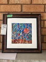 Full view of framed square giclee art print with visible artist signature, mounted on a white mat and encased in a brown frame.