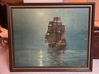 Full view of framed painting showing a large sailing ship on calm water with dusk/dawn sky.