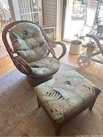 Front view of rattan swivel chair with cushions and matching ottoman