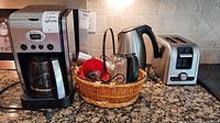 Photo showing full lot on countertop with coffee maker, toaster, kettle, wicker basket with items, and glass carafe.