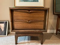 Front view of wooden side table showing two drawers with recessed handles and minor scratches on surface.