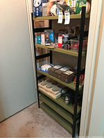 Full view showing one shelving unit loaded with various stored items in basement corner.