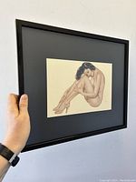 Side angle photo showing framed art held by hand to show depth and frame detail.
