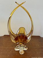 Front view of amber and clear glass abstract basket vase showing crossed upward arms and rounded interior base