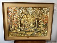 Full front view of the framed oil painting showing autumn forest pathway scene.