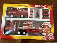 Original Buddy L boxed set with trucks visible through the window, showing intact packaging with some age wear