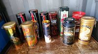 Photo of assorted collectable beverage tins on wooden surface with industrial background