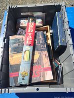 Storage bin contents showing various books, Flower Tapes, and small boxes