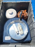 Photo of storage bin containing all kitchenware items stacked with Pyrex case under frying pan.