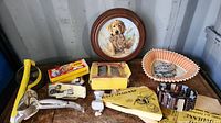 Full view of lot showing decorative plate, vintage kitchenware tools, toy vehicles, and a fan-shaped serving tray