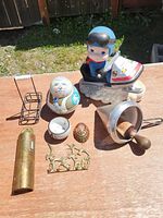 Image showing variety of vintage and metal collectable items placed on wooden surface outdoors in sunlight.