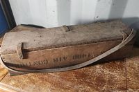 Photo of closed wooden box with carrying strap showing wear and markings