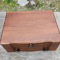 Closed wooden box with visible latch and decorative handles on the sides.