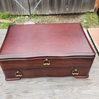Closed wooden box with brass clasps for flatware storage