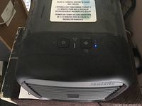 Front top view of the black Homedics mini air conditioner showing control buttons and indicator lights.