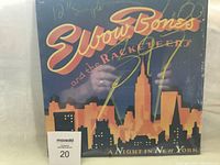 Front cover of Elbow Bones and the Racketeers 'A Night in New York' vinyl album showing city skyline and yellow and red stylized text.
