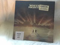 Front cover of the White Nights vinyl album showing two figures walking toward sunlight, with text and stickers.