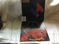 Two rock vinyl albums angled against a white background, showing covers of Heart's Passionworks and The Delacroix live album.