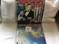 Front view of two vinyl albums by Was (Not Was). One titled 'Inner Sleeve' featuring two men in tuxedos on the cover, the other a colorful album under plastic wrap.
