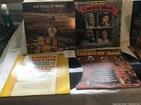 Four country and western vinyl albums arranged, visible titles and cover art featuring traditional country music imagery and artists.