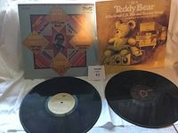 Two vinyl records displayed with their respective album covers, showing front artwork and some text.