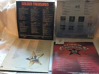 Four vinyl country music albums arranged showing front and back covers plus inner sleeve.