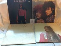 Front covers of four vintage vinyl music albums including Laura Branigan and Rockchairs artists.