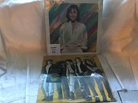 Front view of the two sealed vinyl albums featuring REO Speedwagon and a colorful album with a man in white shirt.