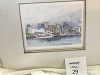 Framed watercolor painting showing cityscape with boats on water, signed by Gerard Paraghamian.