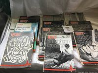 Photo showing multiple QST magazines arranged side by side covering amateur radio topics