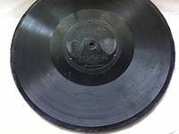 Top view of black antique clay record with Edison label showing, side one of the record 'Stars and Stripes Forever'.