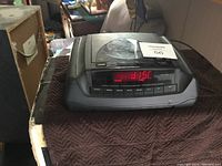 Front-top angle view of the GE compact disc player on a box, showing its control panel and digital display with red digits.