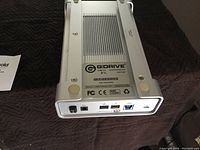 Photo showing the back panel of the silver aluminum G-Drive external hard drive with USB 3.0, two Thunderbolt ports, and power input. The label displays 2TB capacity and USB 3.0 interface.