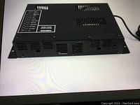 Top and front angle view of the new Bogen model 790P P.A. amplifier showing the metal casing, ventilation slots, and label with input/output connections.