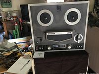 Front view of vintage Toshiba reel to reel tape recorder showing reels, controls, and label.