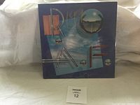 Front cover of the Roaf LP record showing the artwork of clouds, metallic spheres, and text.